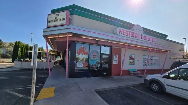 Westside Diner exterior with pink trim, sign, and a parked car on a sunny day.