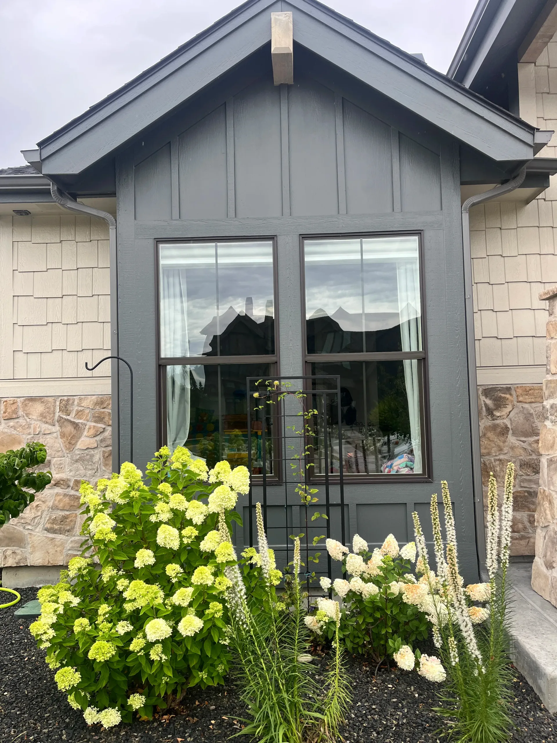 Front windows and entry of a Boise home with flowers in the garden bed