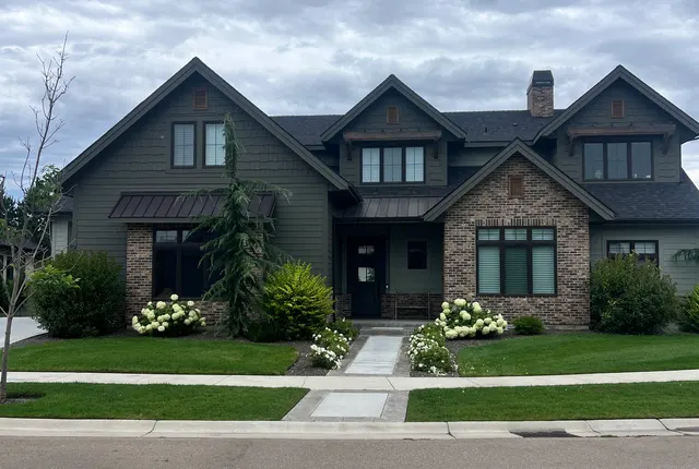 Green craftsman home in Boise with clean, streak-free windows and manicured landscaping viewed from the street Green craftsman home in Boise with clean, streak-free windows and manicured landscaping viewed from the street